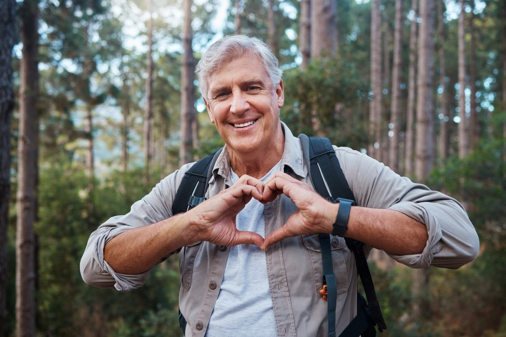 Portrait,,heart,and,senior,man,in,forest,hiking,,fitness,and