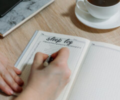 Woman,hand,with,sleep,log,or,diary,on,table.,how